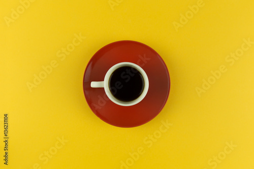Coffee cup and saucer on bright yellow background