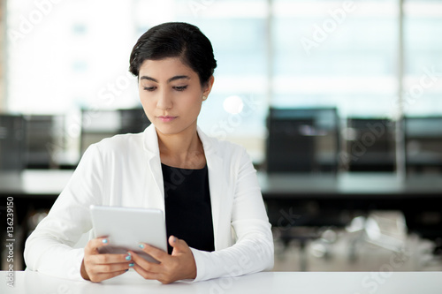 Confident Asian businesswoman using digital tablet