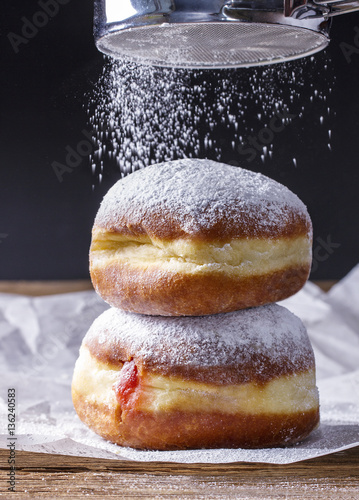 Fresh donuts with strawberry jam, sprinkled with powdered sugar
