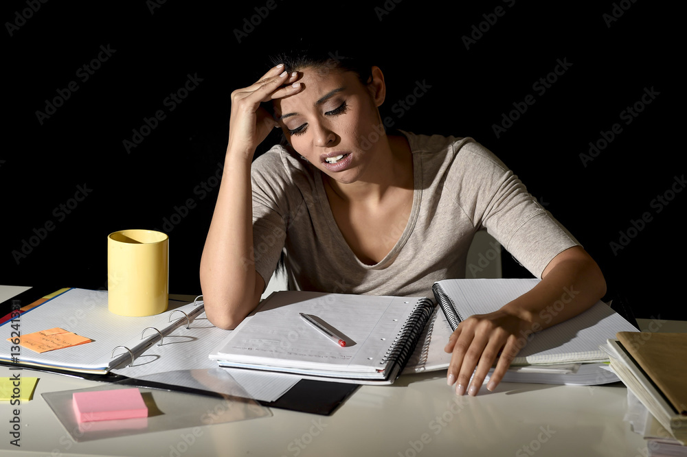 Spanish girl studying tired and bored at home late night looking sad and stressed preparing exam Spanish girl studying tired and bored at home late night looking sad and stressed preparing exam