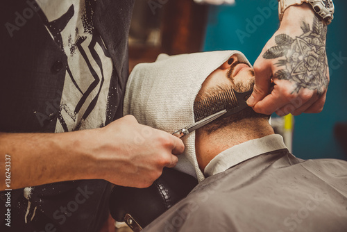 man shaving his beard in the professional hairdresser