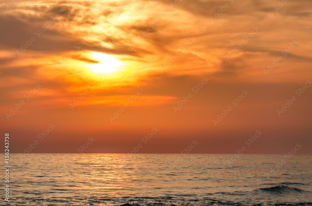 Beautiful orange sunset with wispy clouds. Tourist travel destination location.  Beach shoreline setting for background or backdrop.
