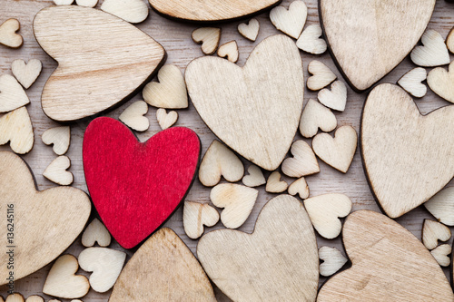 Wooden hearts, one red heart on the heart background.