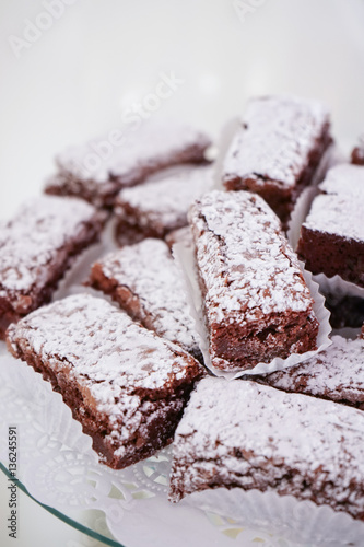 Brownie with glazed sugar in the top  on a white table on a white background.