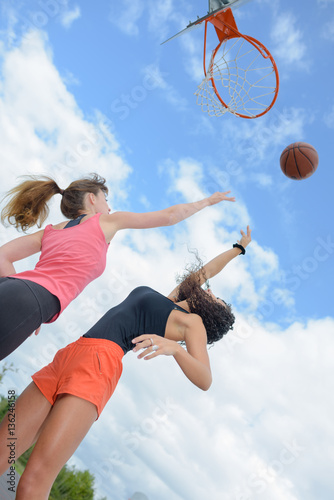 Upward view of two women playing basketball © auremar