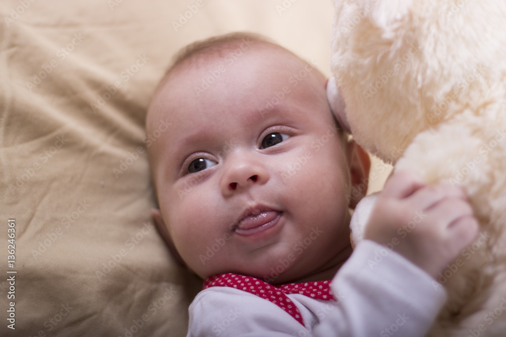 Close up beautiful baby girl playing with her toys. Newborn kid with a toy bear. Close up beautiful baby girl playing with her toys. Newborn kid with a toy bear.