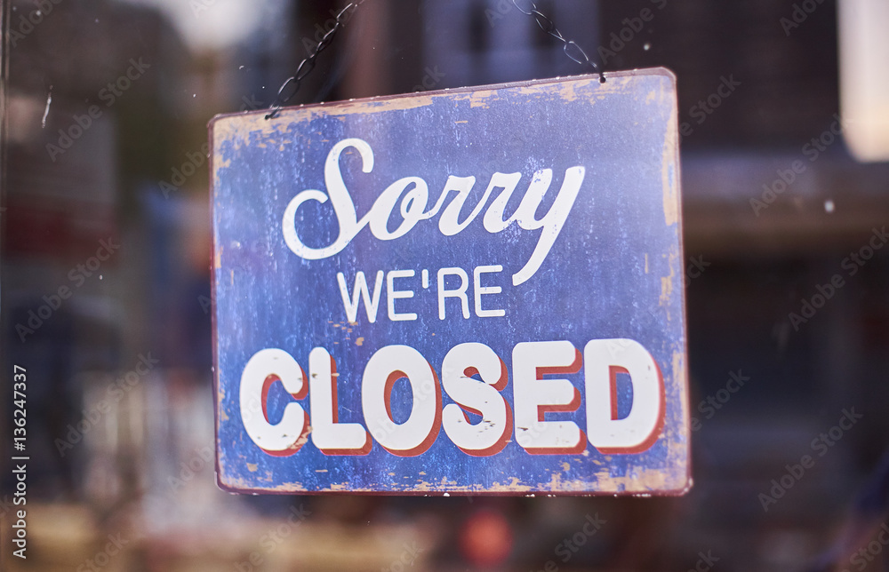 sorry we're closed shop sign hanging in a window Photos | Adobe Stock