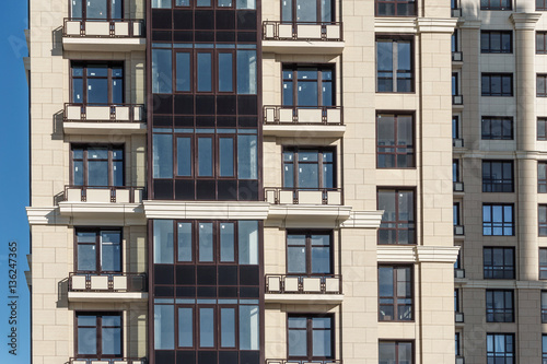 Facade of modern apartment flat house with balconies and windows. 