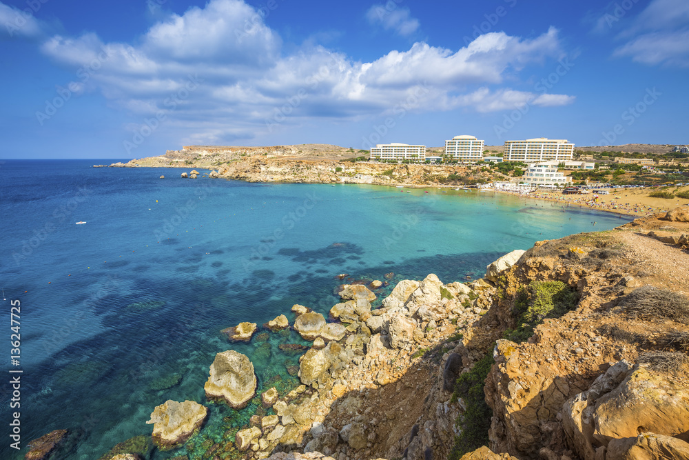 Ghajn Tuffieha, Malta - Panoramic skyline view of Golden Bay, Malta's most beautiful sandy beach on a nice summer day with blue sky and clouds