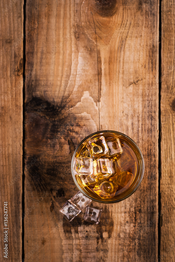 Fototapeta premium Glass of whiskey on wooden table