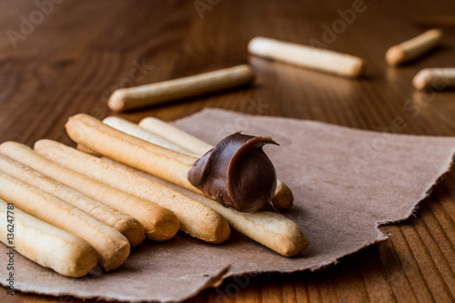 Grissini with Chocolate cream on wooden surface.