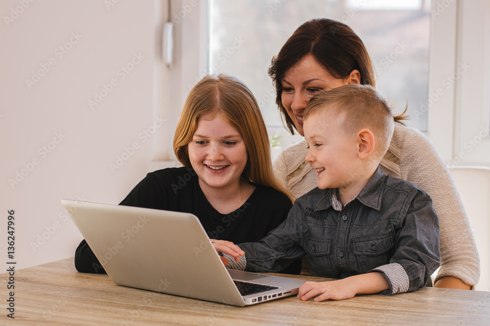 Mother with kids playing on laptop computer Mother with kids playing on laptop computer