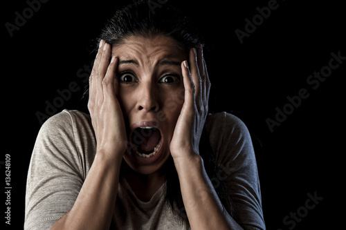 close up portrait young attractive Latin woman screaming desperate screaming in primal fear emotion photo