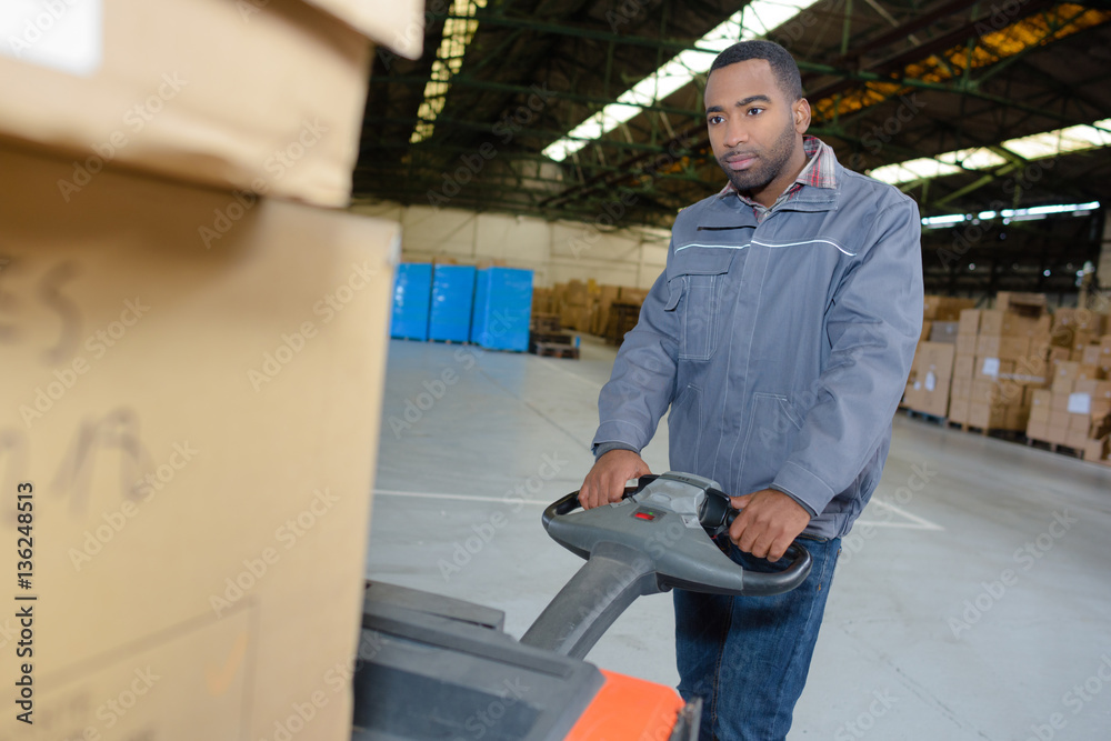 Warehouse worker using pallet truck Warehouse worker using pallet truck