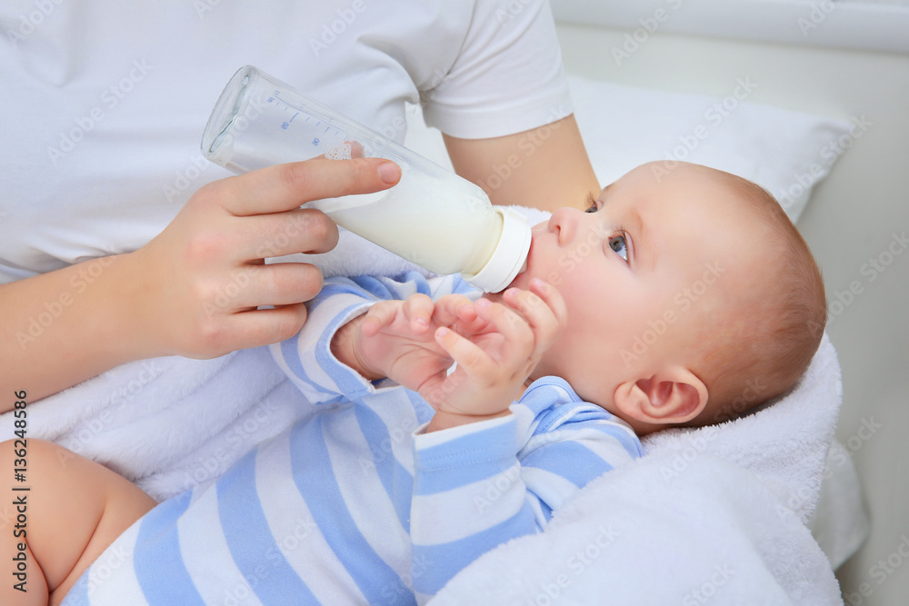 Mother holding and feeding baby from bottle Mother holding and feeding baby from bottle