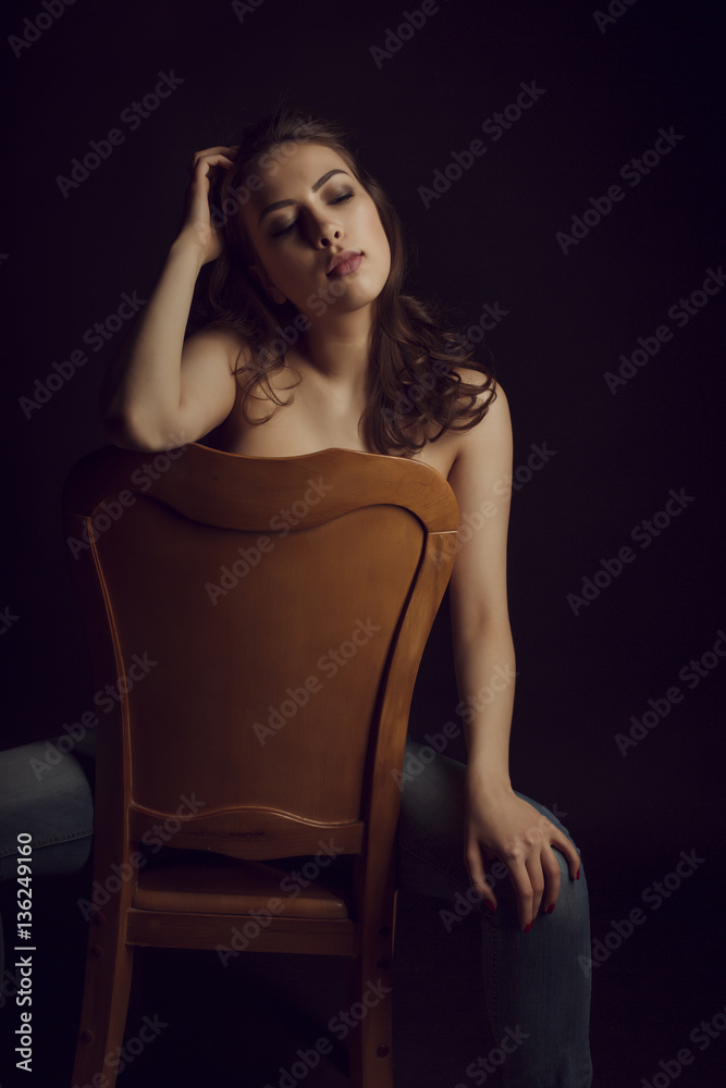 Luxurious topless woman with lush hair in the dark room