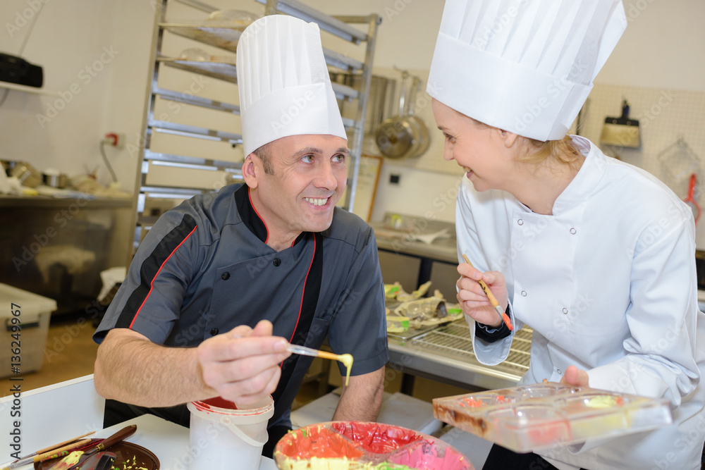 portrait of a cheerful professional pastry cooks portrait of a cheerful professional pastry cooks