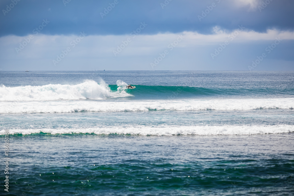 Tropical surfing on blue wave in Bali. Paradise. Water sport 