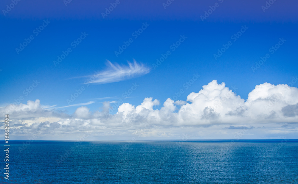 seascape of calm pacific ocean on clear day with fluffy clouds