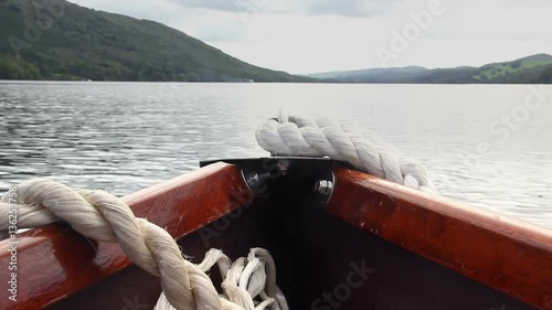 The bow of a rowing boat point of view (POV), rocking a little as the boat is rowed across Coniston Water in the English Lake District.