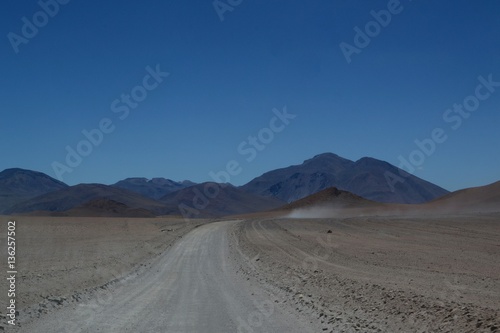 Dirt road heading into the distance across the dusty remote desert and Altiplano region of South West Bolivia