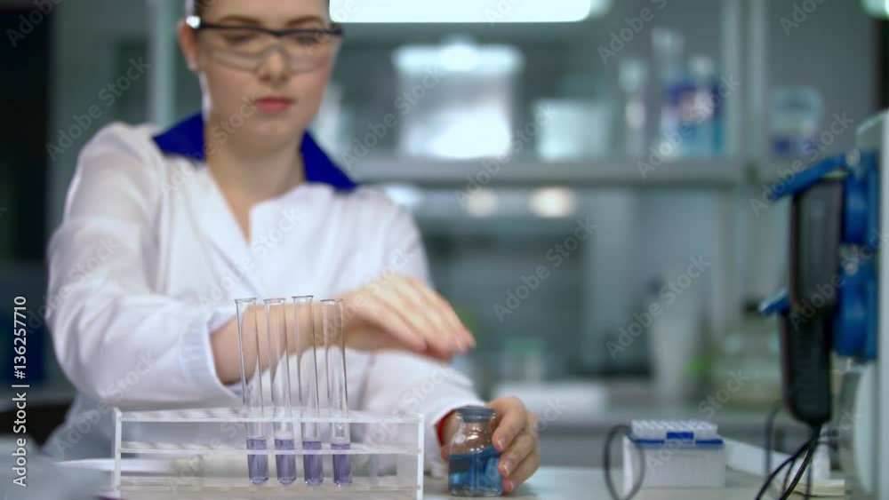 Pharmacist working with liquid in test tube. Female scientist doing pharmaceutical research in chemical laboratory. Doctor mixing chemical liquid in glass flask. Medical research in chemical lab Pharmacist working with liquid in test tube. Female scientist doing pharmaceutical research in chemical laboratory. Doctor mixing chemical liquid in glass flask. Medical research in chemical lab