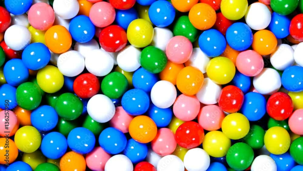 A rotating bowl of sweet candy gumballs in various bright colors. A rotating bowl of sweet candy gumballs in various bright colors.
