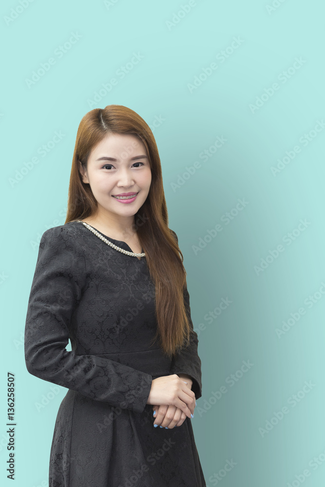 A pretty Asian business women standing with the light green wall background A pretty Asian business women standing with the light green wall background