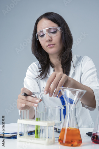 Female Laboratory Staff Working with Liquids in Flasks In Laboratory