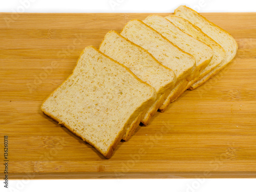 Side view of slices of toast bread on breadboard wooden, isolated on white background.