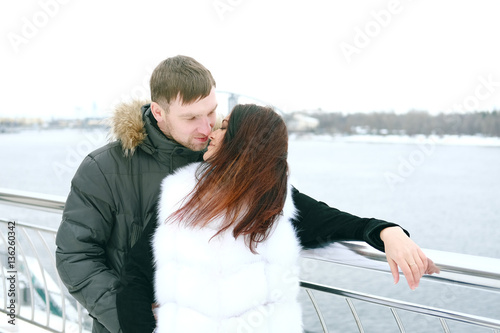Winter love story. Young couple engagement outdoors near the riv