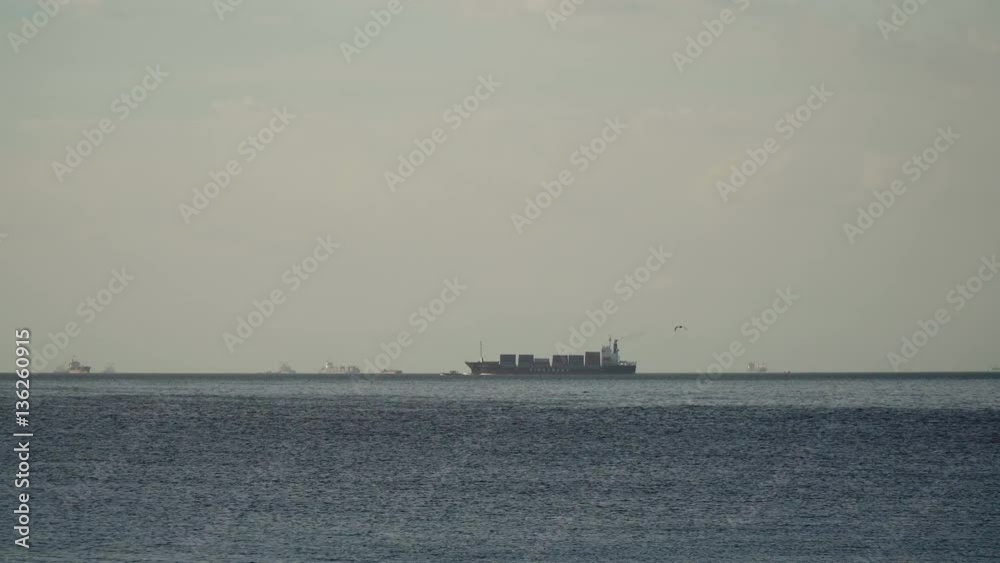 Cargo ship with containers floating on the sea. Cargo ships in the Bay of Manila. Large container ship in the sea, blue sky and clouds. 4K video. Philippines, Manila. Cargo ship with containers floating on the sea. Cargo ships in the Bay of Manila. Large container ship in the sea, blue sky and clouds. 4K video. Philippines, Manila.