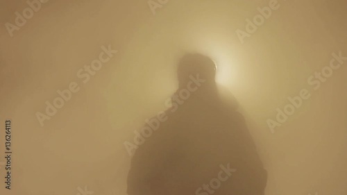 silhouette of young man enveloped by steam on the night city road