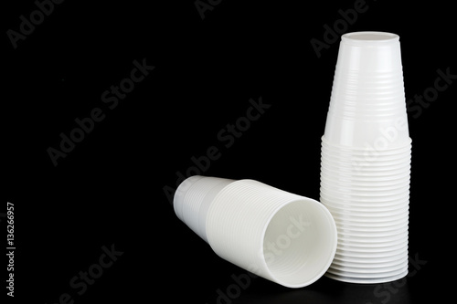 stacking white plastic cups isolated on black background