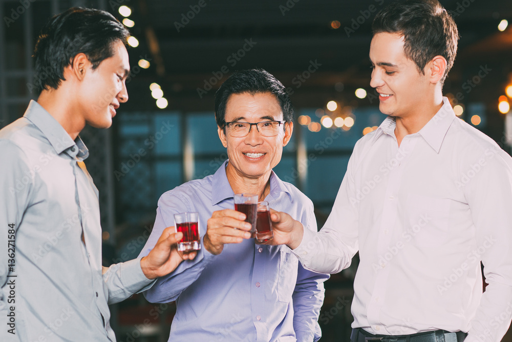 Three Smiling Men Toasting in Bar