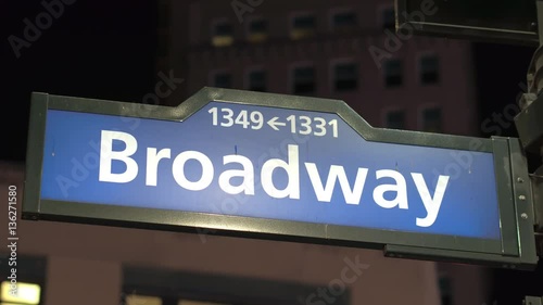 CLOSE UP: Blue Broadway road sign with numbers at street corner in New York