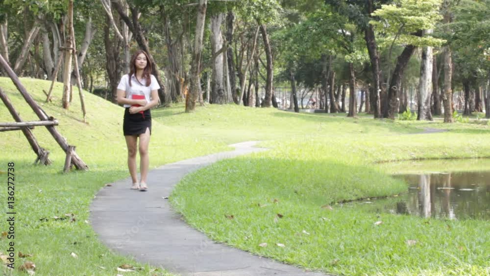 Portrait of thai adult student university uniform beautiful girl walk relaxed and smile.
