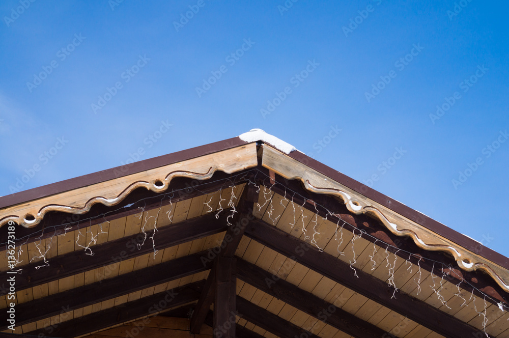 Closeup shows the edge of the roof with decorative trim.