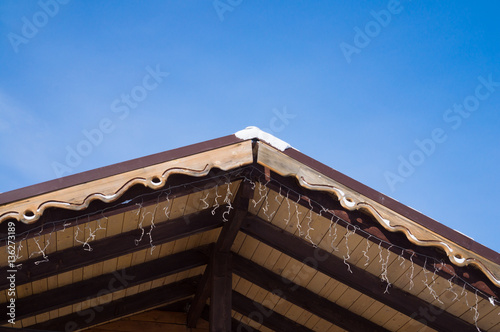 Closeup shows the edge of the roof with decorative trim.