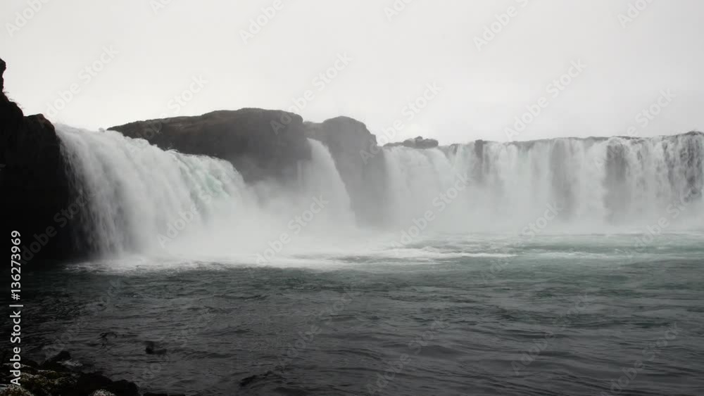 Godafoss waterfall in Iceland during a rainy, overcast morning shows the misty, eerie scenery as the water spills over the ledge. Godafoss waterfall in Iceland during a rainy, overcast morning shows the misty, eerie scenery as the water spills over the ledge.
