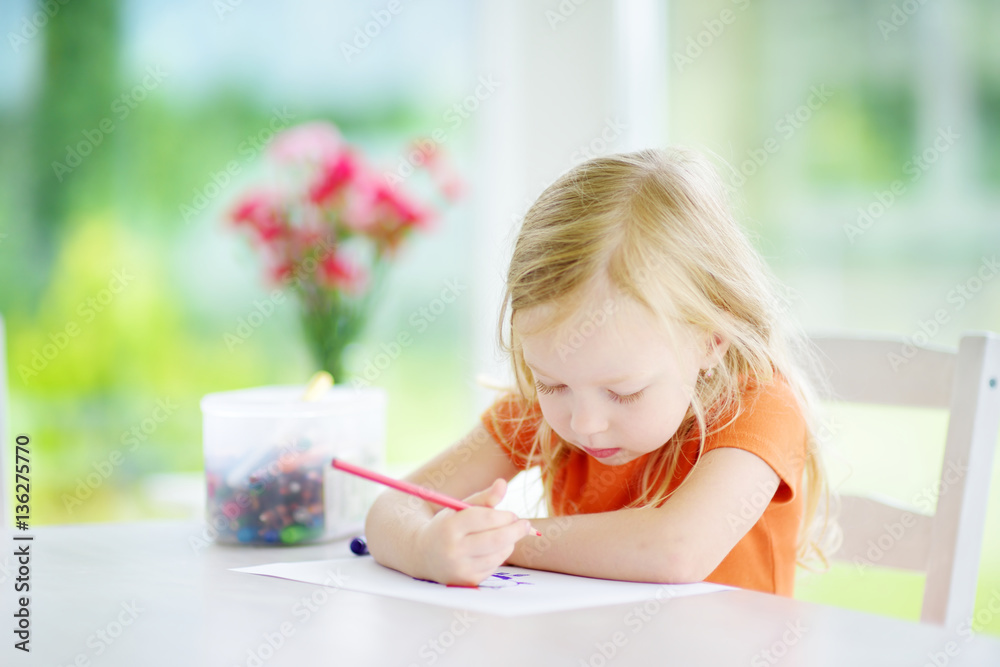 Cute little girl drawing with pencils at a daycare. Creative kid painting at school. Girl doing homework at home. Cute little girl drawing with pencils at a daycare. Creative kid painting at school. Girl doing homework at home.