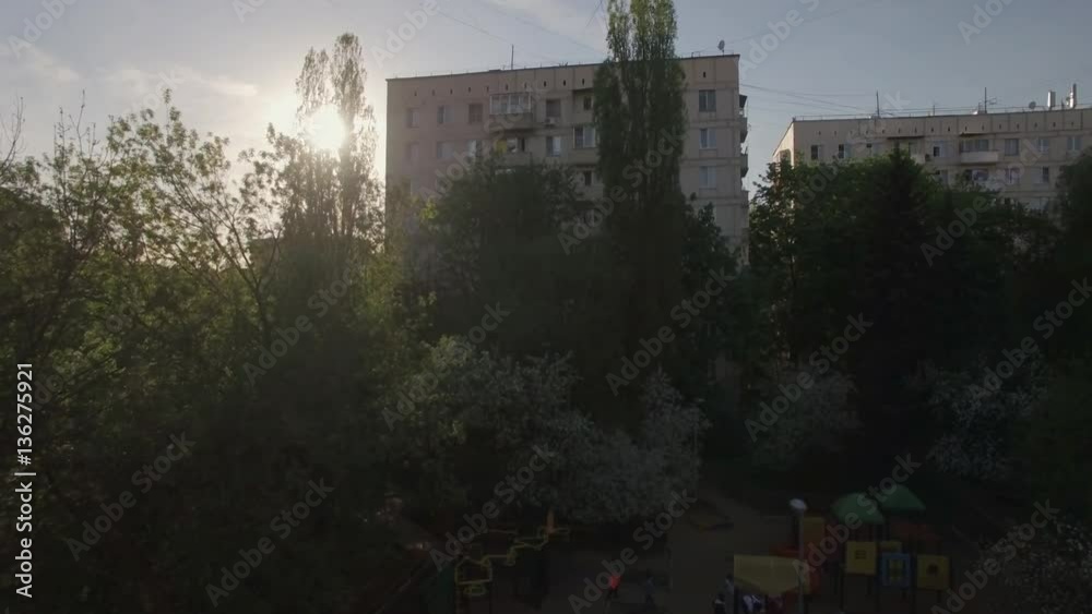 Flying to the old multistorey apartment block in the yard with playground. Moscow, Russia Flying to the old multistorey apartment block in the yard with playground. Moscow, Russia