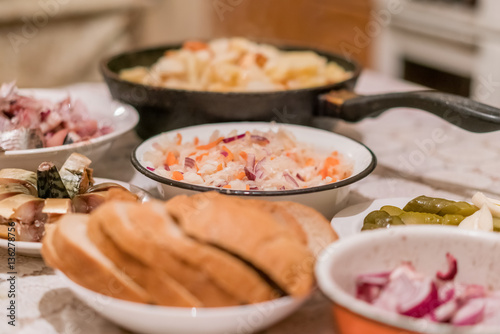 Country dinner with roast potatoes, smoked fish, pickles, bread and coleslaw
