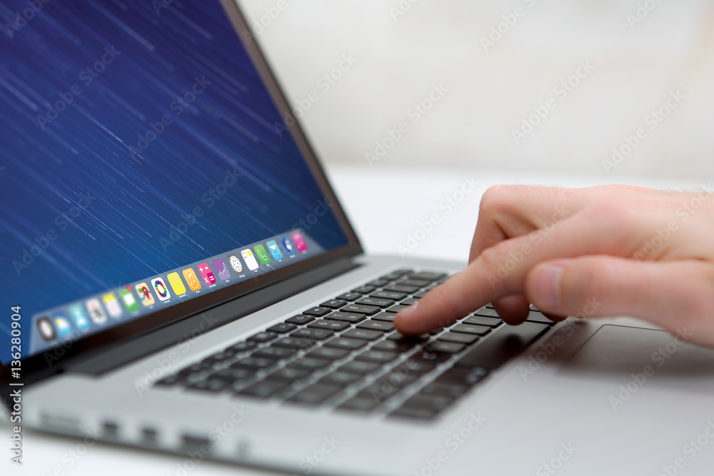 Hand typing on a keyboard of laptop with operating system screen on background