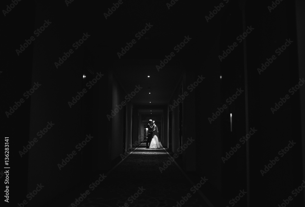 Fototapeta premium Bride and her husband go narrow corridor
