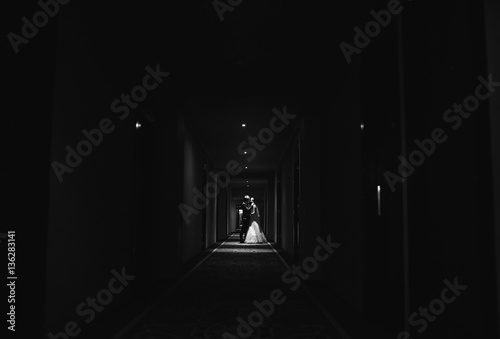 Bride and her husband go  narrow corridor