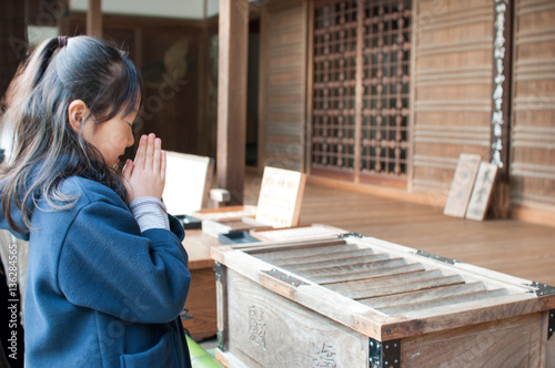神社で願い事をする少女