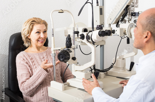 Fototapeta Naklejka Na Ścianę i Meble -  Mature optician examinating eyesight with aid of slit lamp