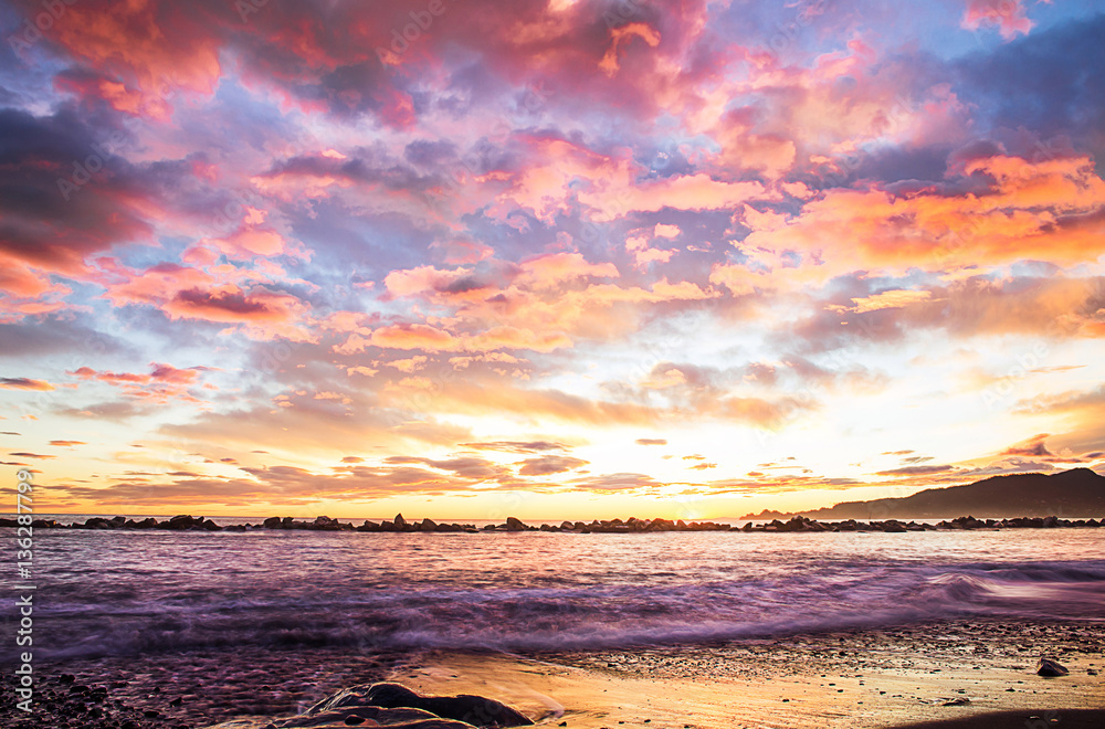 Fototapeta premium romantic clouds over beach at sunset