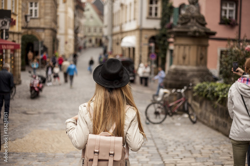 A woman with a hat from the back in ancient Europe city